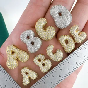 Detailed view of trendy cubic zirconia bubble letter copper pendants for DIY fashion jewelry.