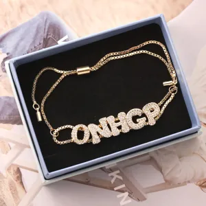 Gold-plated adjustable slider bracelet with micro-paved cubic zirconia letter charms for women.