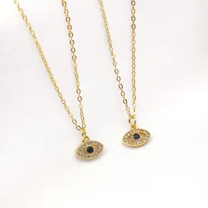 Detailed close-up of gold evil eye pendant necklace with sparkling pavé crystals and blue stone.