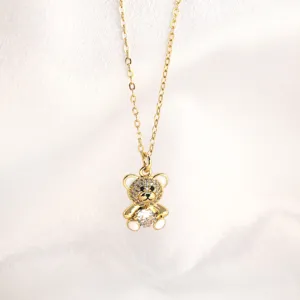 Gold teddy bear necklace detail featuring sparkling crystal pendant and delicate link chain.