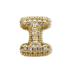 Detaillierte Nahaufnahme eines goldenen Strass-Buchstaben-Anhängers mit funkelnden Zirkonia-Steinen.