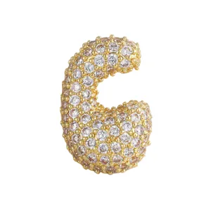 Dettaglio del ciondolo lettera C in zircone dorato stile hip-hop, accessorio collana.