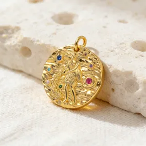 Primo piano dettagliato di un ciondolo zodiacale placcato in oro con pietre zirconi colorate.