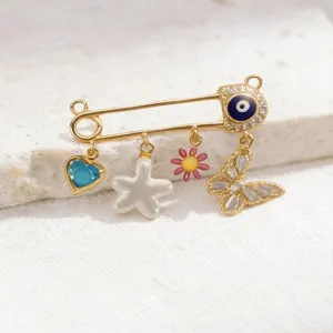 Close-up details of gold evil eye safety pin brooch with multi charms sweet style.