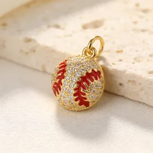 Gros plan détaillé du pendentif de baseball plaqué or avec zircons cubiques scintillants et émail rouge.