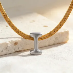 Nahaufnahme Detail einer minimalistischen Gold Schlangenkette mit Silber Anhänger Schmuck.