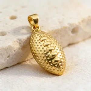 Pendentif ballon de rugby doré en gros plan, surface texturée délicate, accessoire idéal.