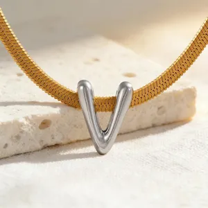 Nahaufnahme eines zweifarbigen V-förmigen Anhängers an einer goldenen Schlangenkette.