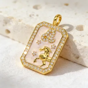Gold plated zodiac constellation pendant necklace with sparkling cubic zirconia and pink enamel.