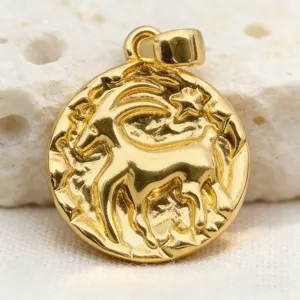 Close-up detail of vintage gold zodiac coin pendant with textured relief design and glossy finish.