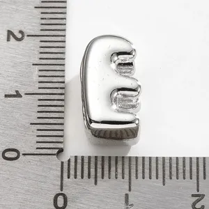 Pendentif en métal argenté lettre E vue de détail, idéal pour la création de bijoux DIY.