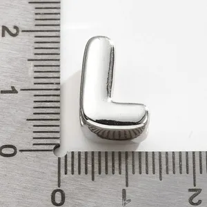 Accessoire pendentif lettre L en métal pour bijoux, présenté avec une règle de mesure.