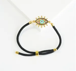 Primo piano dettagliato del bracciale in corda di nylon nera con ciondolo a occhio turco dorato.