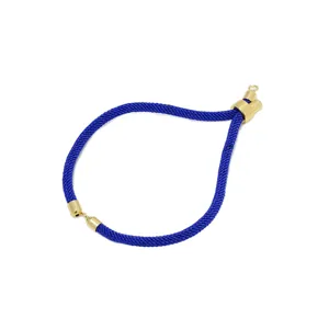 Primo piano dettaglio del bracciale in corda di nylon blu intrecciato con cursori dorati.