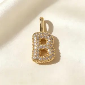 Vergulde letter B hanger detail met schitterende micro-kristallen op fijne zijde.