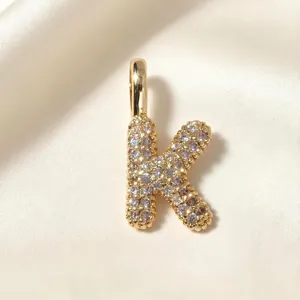 Vergulde letter K hanger sieraden detail close-up, prachtig stralend mode accessoire.