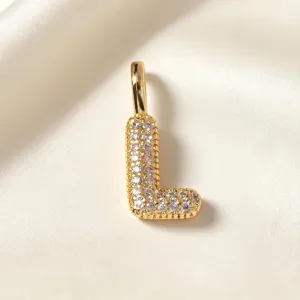 Vergulde letter L hanger, sprankelende kristal pavé, delicate sieraden detail opname.