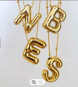 Primo piano dettagliato della collana con ciondolo a lettera di palloncino 3D dorato e catena.