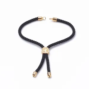 Bracelet en cordon noir réglable avec breloques métalliques dorées et motif arbre de vie.