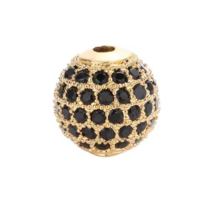 Nahaufnahme einer vergoldeten runden Abstandshalterperle mit Zirkoniasteinen für DIY Schmuck.