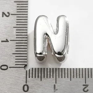 Détail de breloque lettre N en métal argenté, accessoire bijoux DIY pour bracelets.