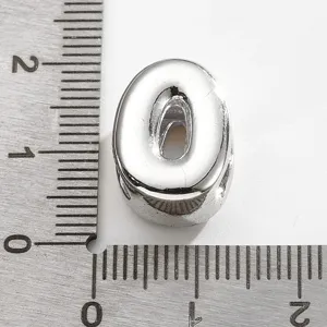 Détail de perle de lettre O en métal argenté avec échelle de taille pour bijoux.