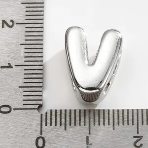 Pendentif lettre V couleur argent accessoire bijoux DIY affiché avec règle de taille.