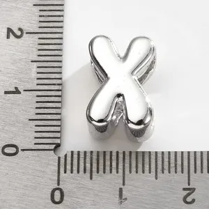 Perle breloque lettre X en métal argenté, vue rapprochée pour fabrication de bijoux.