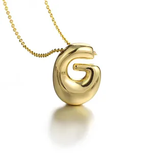 Close-up of a stylish puffed 3D letter G pendant necklace in glossy gold-plated finish.