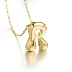 Close-up detail shot of a 3D gold bubble letter R pendant necklace, polished finish.