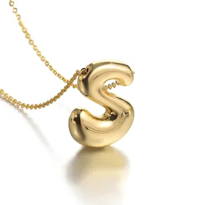 Close-up detail shot of a gold-plated puffy letter S pendant necklace with fine chain.