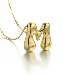 Gold bubble letter M pendant necklace, elegant minimalist fashion jewelry for women.