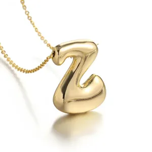 Gold plated balloon letter Z pendant necklace, stylish minimalist design closeup jewelry detail.