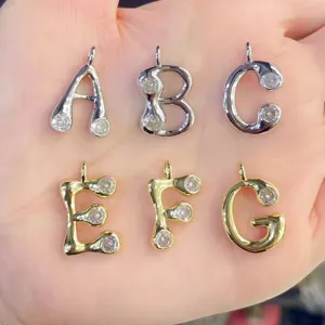 Detailansicht eines modischen 18k vergoldeten Buchstaben-Anhängers mit funkelnden Zirkoniasteinen.