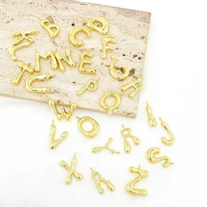 Gedetailleerd overzicht van gouden letterbedels, gedraaide alfabetcomponenten voor sieraden.