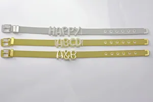 Primo piano di bracciali in maglia con lettere, zirconi pavé e ciondoli in metallo liscio.