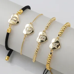 Conjunto de pulseras de cobre chapado en oro con corazón y letras y detalles de pedrería.