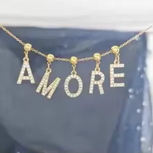 Detail shot of gold rhinestone alphabet letter necklace AMORE charm pendant closeup jewelry