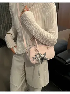 Detailed shot of a stylish light pink shoulder bag with silver star and balloon dog charms.