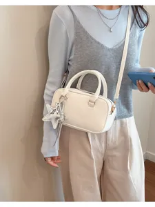 Detail view of stylish white women shoulder bag with star charm and debossed lettering.
