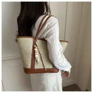 Women summer straw woven tote bag stylish casual shoulder bag with beaded pendant detail view.