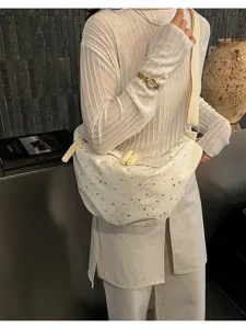 Vista dettagliata di una borsa a tracolla bianca con motivo a stelle e cinturino largo chic.
