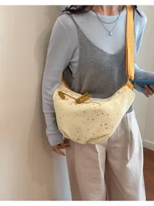 Inquadratura di dettaglio della borsa a tracolla casual con stelle e tracolla intrecciata.