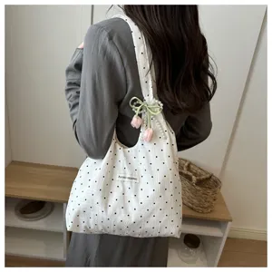 Chic polka dot canvas tote bag featuring cute tulip charms and pearl strap for daily commute.
