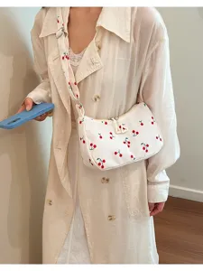 White corduroy shoulder bag detail featuring cute embroidered cherry patterns and matching strap.
