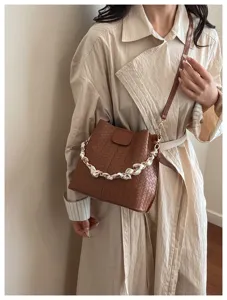 Trendy women's retro woven bucket bag with chain strap and chic design for daily commute.