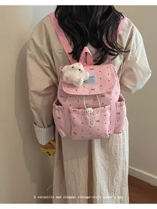 Primo piano del dettaglio zaino rosa a pois con fiocco, stella in peluche e coulisse.