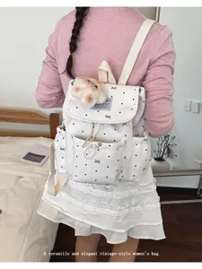 Vista dettagliata dello zaino bianco a pois con stampa fiocco e morbido peluche, stile casual.