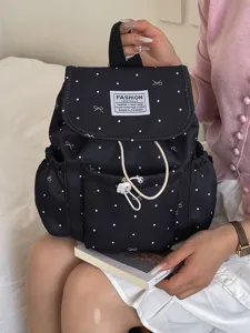 Zaino nero elegante con pois e fiocco, chiusura a coulisse, perfetto per scuola e tempo libero.