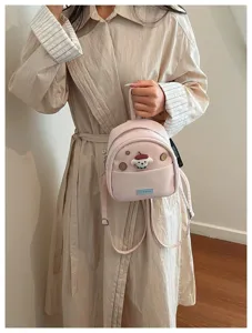 Vue détaillée du mini sac à dos rose mignon avec un patch de chien ludique et une poignée.